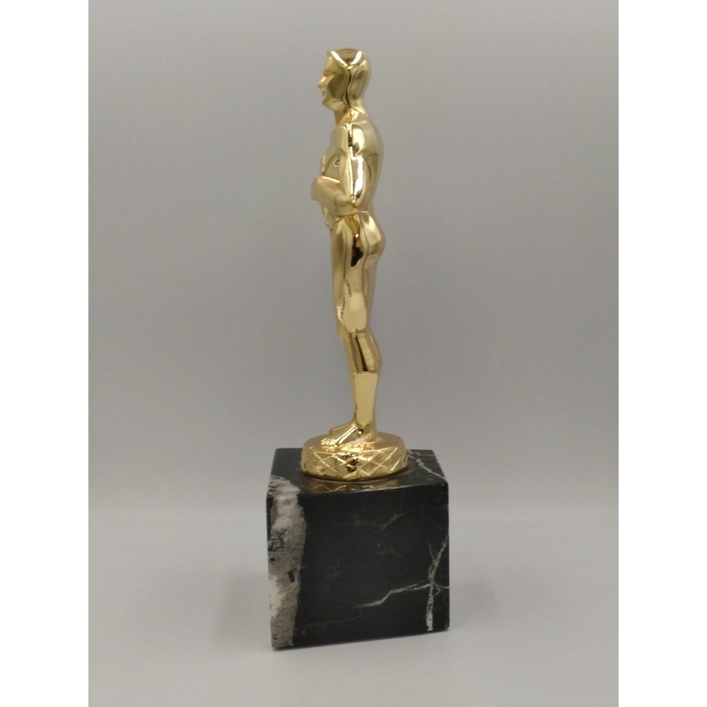 collectible replica Oscar-style achievement trophy featuring a gold figure mount