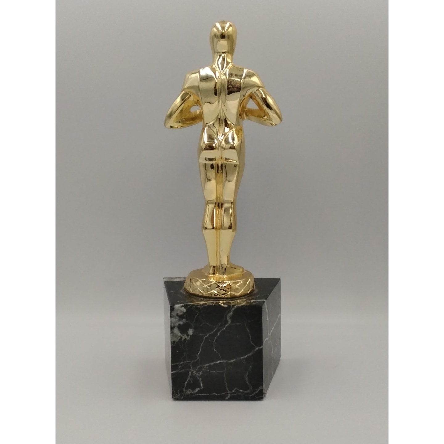 collectible replica Oscar-style achievement trophy featuring a gold figure mount